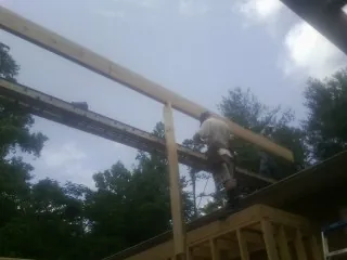 Carpenter setting a ridge beam over a new addition frame — Ice Dam Removal by Roofing Brothers in Neptune