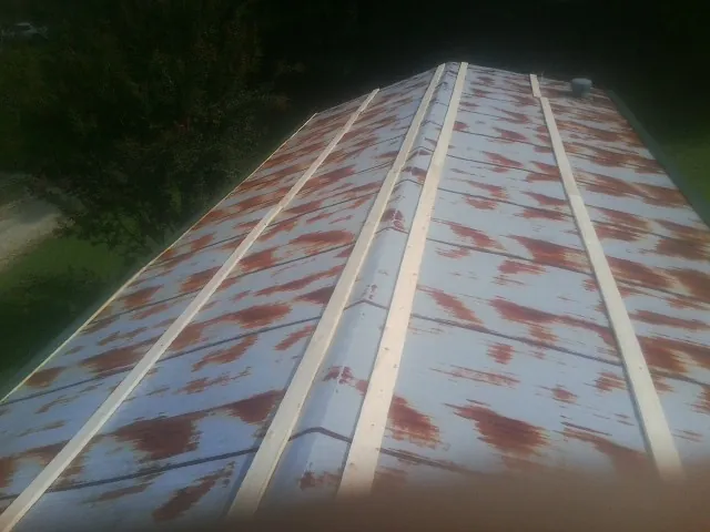 Rusted metal roof panels with new wood purlins before replacement — Storm Damage Roof Repair in Neptune by Roofing Brothers