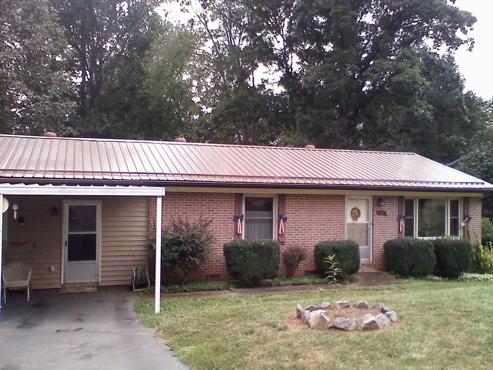 Bronze metal roof and carport on a brick ranch home — Roof Repair work by our crew in Neptune